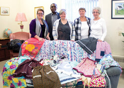 Musset and Gail Pierre-Jérôme (left) join event organizer Cathy Mellon (center) and local 
seamstresses surrounded by some of the many hand made pillowcase dresses that will soon be on their way to Haiti.
Photo: HMH